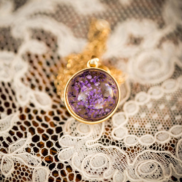 purple dried flower orb silver necklace on lace background