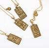 tarot pendant necklaces with zodiac and astrology signs on gold with chain on white backdrop aries aquarius leo capricorn