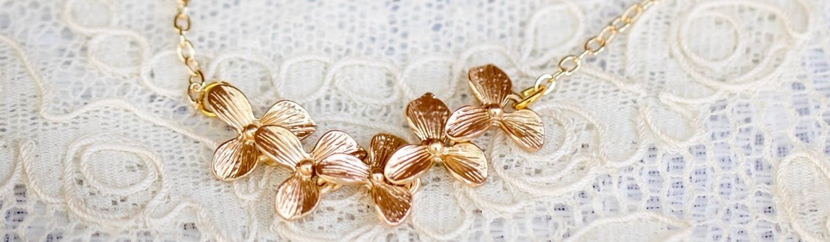 5 orchid blossoms in a row necklace on a lace background