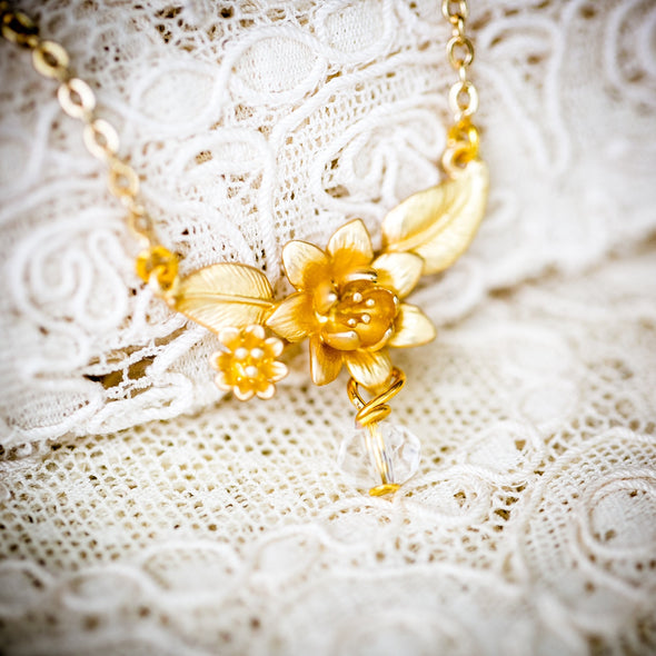 the evelyn lotus flower gold necklace on lace background
