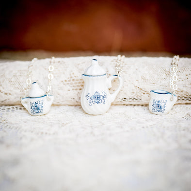 vintage doll house china tea set teacup necklaces blue flower creamer teapot sugar bowl on lace backdrop