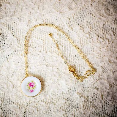 Floral pattern vintage dollhouse china plate necklace on gold chain on lace backdrop