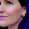 purple haired girl wearing gold lotus earrings