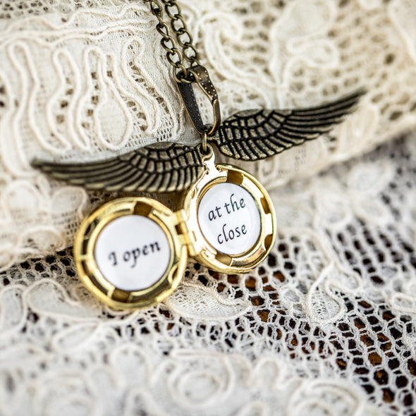 I open at the close golden snitch necklace Harry POtter on a lace background