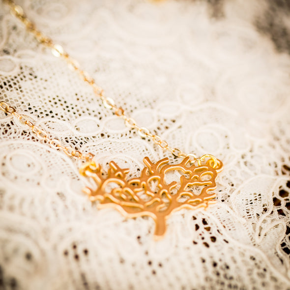 The Kamali small gold necklace on lace (close-up)