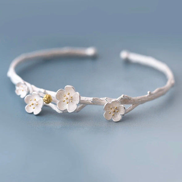 adjustable plum blossom bracelet bangle on blue background