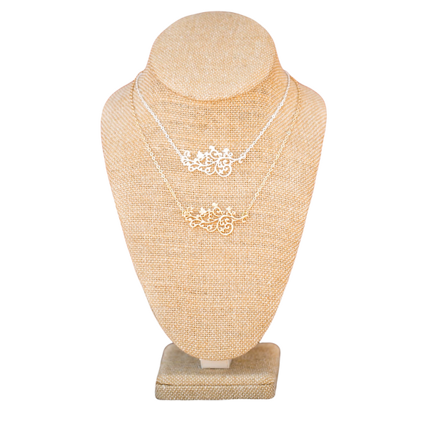 gold and silver filigree necklace with butterflies and flowers on a linen neck on a white backdrop