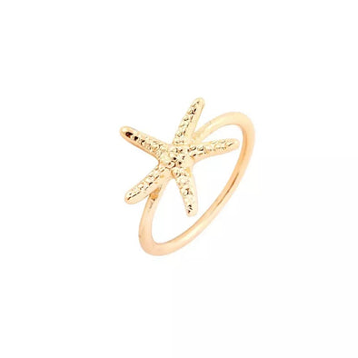 gold starfish ring on white background