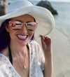 purple haired mermaid girl on beach with shell necklaces