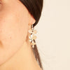 smiling israeli model wearing a orchid 5 petal and blossom necklace and matching earrings 